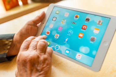 Üst düzey kadın internet üzerinden uygulama kullanarak alışveriş yapıyor, evinde oturuyor. Tablet bilgisayarlı yaşlı kadın. Seçici odaklanma. Yakın plan. Telsiai, Litvanya 05-08-2022.