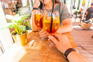 Orta yaşlı erkek ve kadın arasında iki kokteyl bardağı açık hava kahvesini teslim etti. Yakın tatil kavramı..