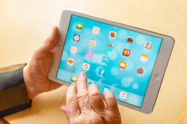 Üst düzey kadın internet üzerinden uygulama kullanarak alışveriş yapıyor, evinde oturuyor. Tablet bilgisayarlı yaşlı kadın. Seçici odaklanma. Yakın plan. Telsiai, Litvanya 05-08-2022.