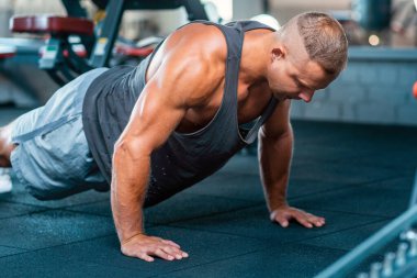 Kaslı adam spor salonunda egzersiz yapıyor. Yaklaş..