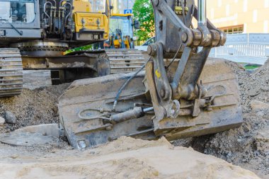 Kazıcı yol onarımı üzerinde çalışıyor. Yol çalışması. Küçük bir kasabada yol onarımı. Kapatın..
