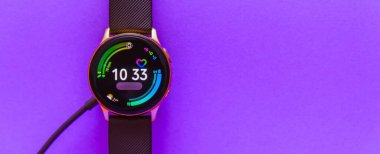 Banner, reklamı.martwatch charging.Smart kablosuz şarj göstergesini ekrandaki şarj göstergesiyle izleyin. Bulanık mor, veri peri renk arkaplanı. Kopyala uzayı. Telsiai, Litvanya.07-01-2022.