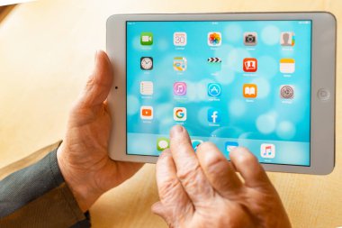 Üst düzey kadın internet üzerinden uygulama kullanarak alışveriş yapıyor, evinde oturuyor. Tablet bilgisayarlı yaşlı kadın. Seçici odaklanma. Yakın plan. Telsiai, Litvanya 05-08-2022.