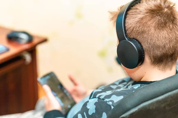 Uroczy Latek Noszący Słuchawki Słucha Muzyki Domu Smartfonem Zbliżenie Selektywne — Zdjęcie stockowe