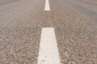 İşaretleme çizgileri olan asfalt yol arkaplanı. foto seçmeli odağı kapat.