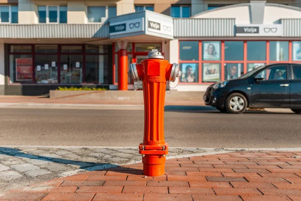 Fire Hydrant in the City.One red color hydrant on the street near blurred building.