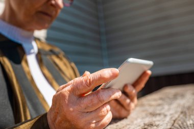 Kıdemli bir kadın yaz günü dışarıdaki bilgisayardan video görüşmesi yapıyor..