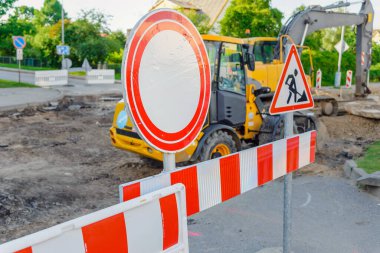 Yol onarımında çalışan bulanık traktör, yolu kapatan sarı bulanık buldozer, yol işaretli bir yol..