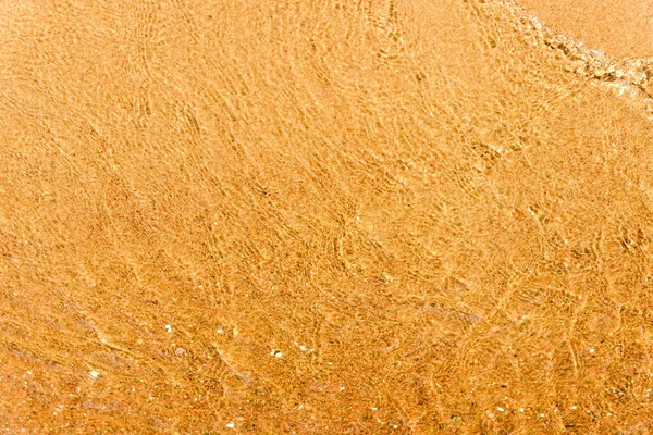 透明而干净的黄色水 有阳光反射的沙地背景 顶视图 夏季自然日光浴 复制空间 — 图库照片