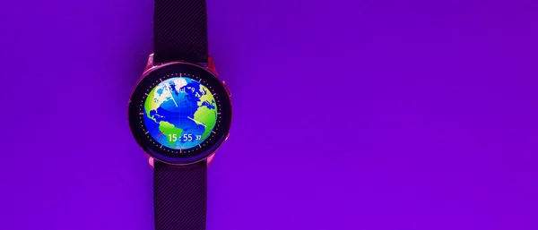 Banner,advertisement business image.Smart watch on the glowing neon purple,veri peri color background with empty space for your text.Closeup,copy space.