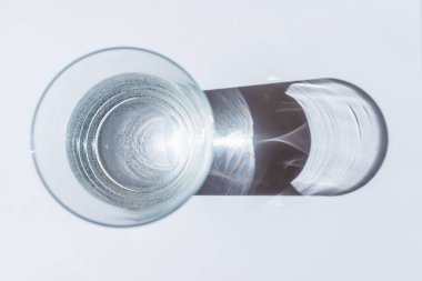 Beyaz arka planda güneş gölgeli su camları. Camların arasından güneş ışığı..