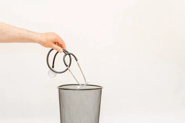 The stethoscope is thrown into the trash for disposal and recycling.White background,selective focus,copy space.