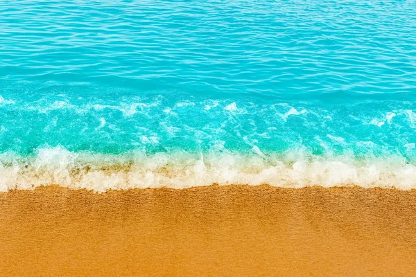 Blue sea wave,golden sand beach,white foam,turquoise ocean water.Close-up.Summer holidays concept.Tropical island vacation backdrop,tourist travel banner design template, copy space.