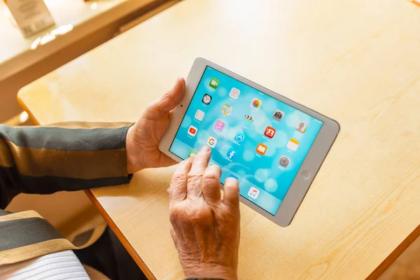 Üst düzey kadın internet üzerinden uygulama kullanarak alışveriş yapıyor, evinde oturuyor. Tablet bilgisayarlı yaşlı kadın. Seçici odaklanma. Yakın plan. Telsiai, Litvanya 05-08-2022.