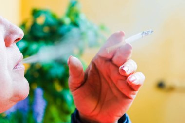 Sigara içen orta yaşlı bir kadın. Ağzında sigara olan bir kadına yakın dur. Geçmişi bulanık..