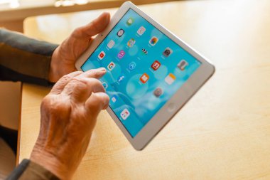 Üst düzey kadın internet üzerinden uygulama kullanarak alışveriş yapıyor, evinde oturuyor. Tablet bilgisayarlı yaşlı kadın. Seçici odaklanma. Yakın plan. Telsiai, Litvanya 05-08-2022.