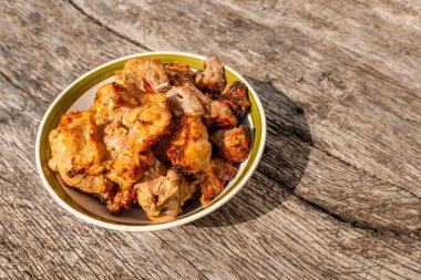 Shashlik, dışarıdaki eski gri meşe masasının kasesinde barbekü yaptı. Yakın çekim..