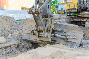 Kazıcı yol onarımı üzerinde çalışıyor. Yol çalışması. Küçük bir kasabada yol onarımı. Kapatın..