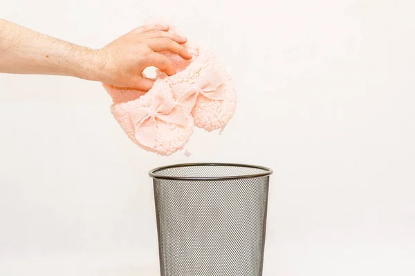 The slippers is thrown into the trash for disposal and recycling.White,gray background,selective focus,copy space.