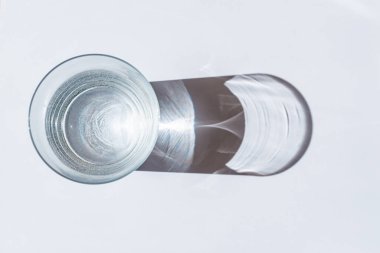 Beyaz arka planda güneş gölgeli su camları. Camların arasından güneş ışığı..