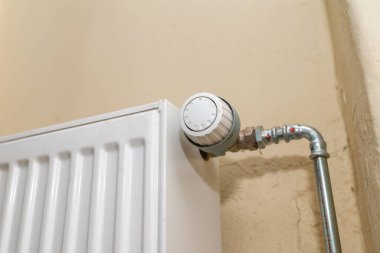 Old white radiator thermostat with copy space,closeup,selective focus,yellow background.