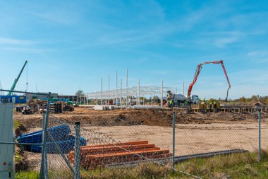 Makineli kentsel alan, araba çimento karıştırıcısı, insanlar inşaat alanında çalışıyor. Telsiai, Litvanya 05-10-2022.