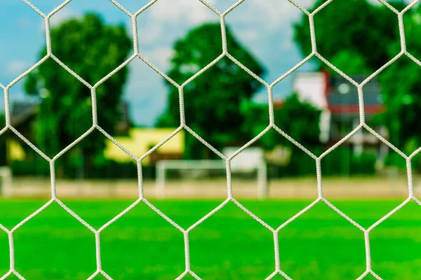 Nets of a soccer field.Empty soccer goal on a soccer green lawn field.Bright summer day.Selective focus.Closeup.