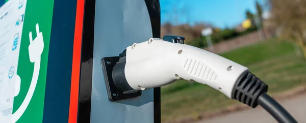 Banner image.power cord for electric car. Green station.Power supply for electric car battery charging.Selective focus.Closeup.