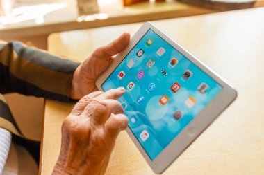 Üst düzey kadın internet üzerinden uygulama kullanarak alışveriş yapıyor, evinde oturuyor. Tablet bilgisayarlı yaşlı kadın. Seçici odaklanma. Yakın plan. Telsiai, Litvanya 05-08-2022.