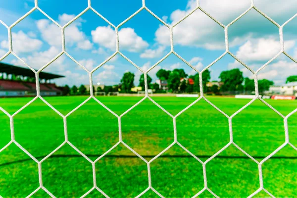 Nets of a soccer field.Empty soccer goal on a soccer green lawn field.Bright summer day.Selective focus.Closeup.