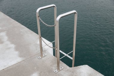 Mavi deniz arka planında bir el. Bir insanın eli okyanusa ulaşıyor..