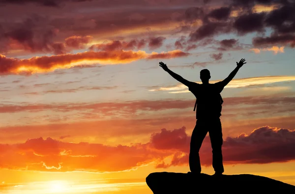 Silhouet van een man op een bergtop op avondrood achtergrond — Stockfoto