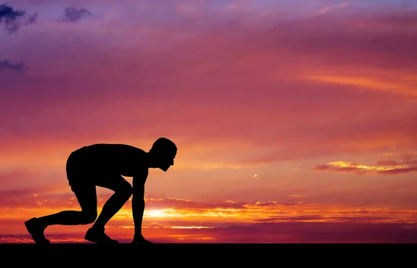 Silueta de atleta en posición para correr sobre fondo de atardecer —  Fotos de Stock