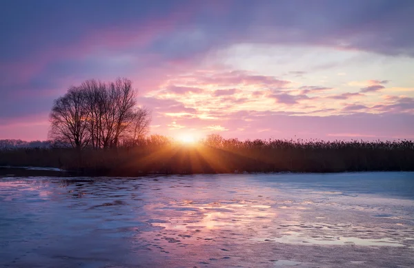 Paesaggio invernale con sole all'alba e fiume ghiacciato . — Foto Stock