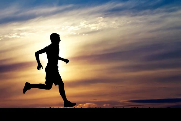 Silueta běžící muž na slunce pozadí — Stock fotografie