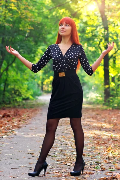 Осенью красивая девушка стоит в парке. Девочка восхищается — стоковое фото