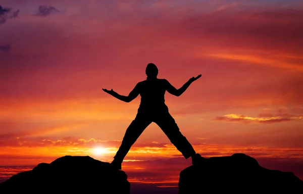 Silhouette of man on sunset fiery sky background — Stock Photo, Image