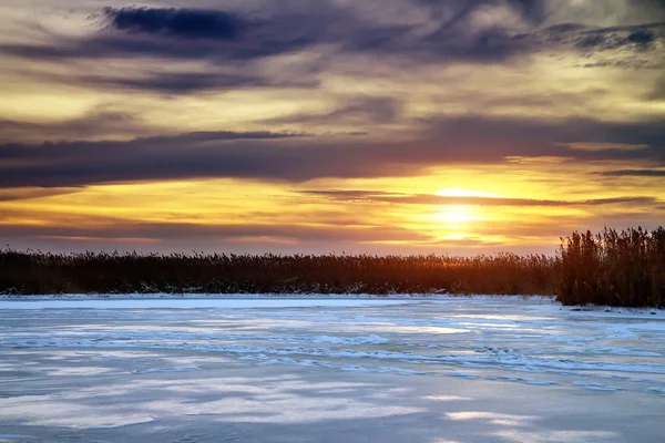 Winter landscape with sun and frozen river. Sunrise.