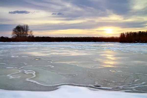 Winterlandschap met zon en bevroren rivier. zonsopgang. — Stockfoto