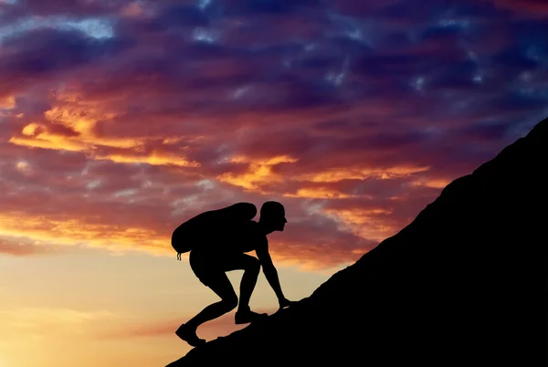 Silhuetten av en man som klättrar berg — Stockfoto