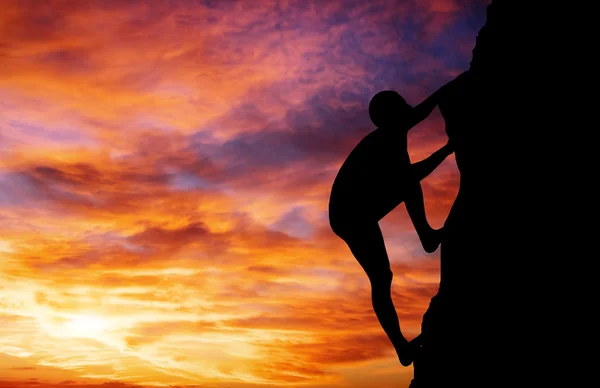 Rock klättrare på sunset bakgrund. sport och aktivt liv — Stockfoto