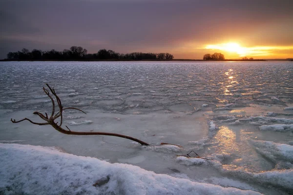 Vinterlandskap med frusen sjö, haken och solnedgång himlen — Stockfoto