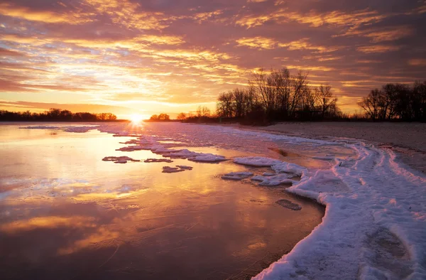 Winter landscape with lake and sunset fiery sky. — Stock Photo, Image