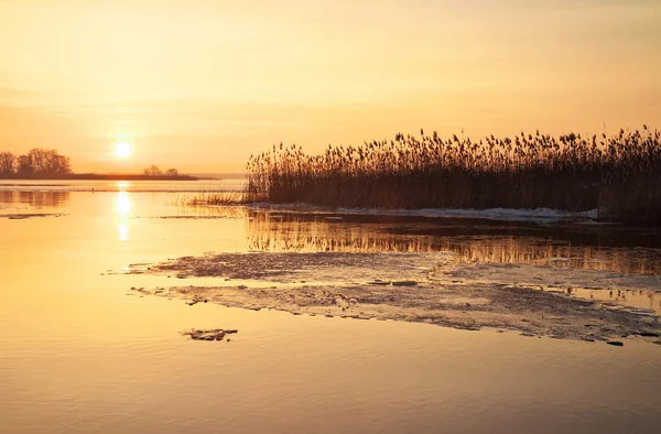 Pemandangan musim dingin dengan sungai dan matahari terbenam langit . — Stok Foto