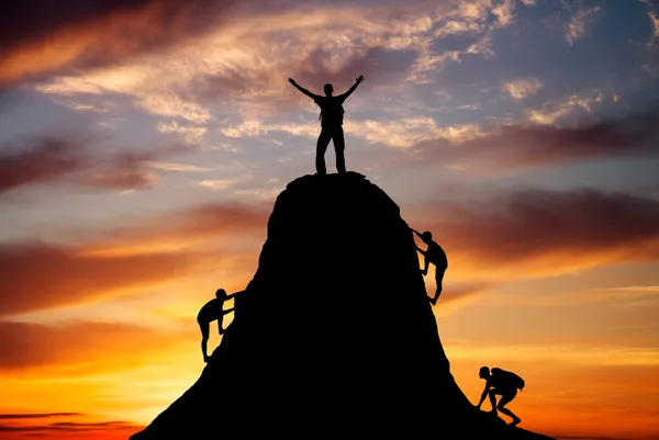 Man on top of the mountain and the other people to climb up — Stock Photo, Image