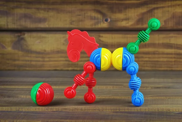 Giocattolo cavallo e palla in plastica dettagli colorati su legno — Foto Stock