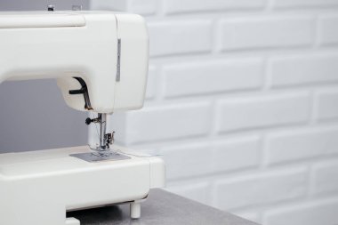 Dikiş atölyesindeki bir masada dikiş makinesi.