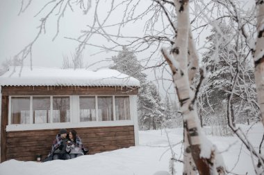 Ormanda aşık genç bir çift battaniyenin altında güneşleniyor. Termostan çay içiyorlar.
