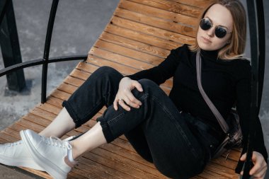 Güzel genç hippi kız parkta bir hamak sandalyesinde dinleniyor.