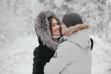 Kış ve randevu. Genç bir çift, kışın ormandaki karla kaplı ağaçların arkasında bir kadınla bir erkeğe aşık olur. Yakın plan.